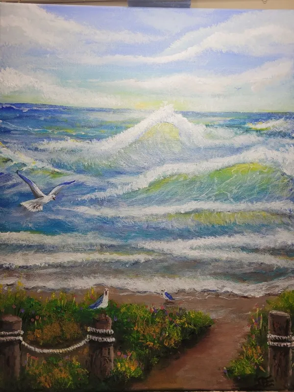 Blue and green ocean waves breaking toward a sandy shore, with gulls, flowering plants and rope-linked wooden posts beside a beach path.